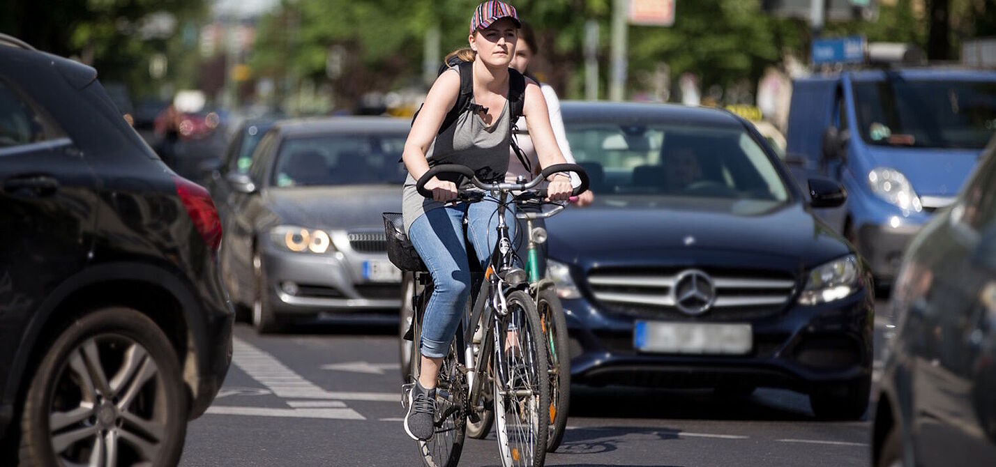 Radfahrerin zwischen Autos